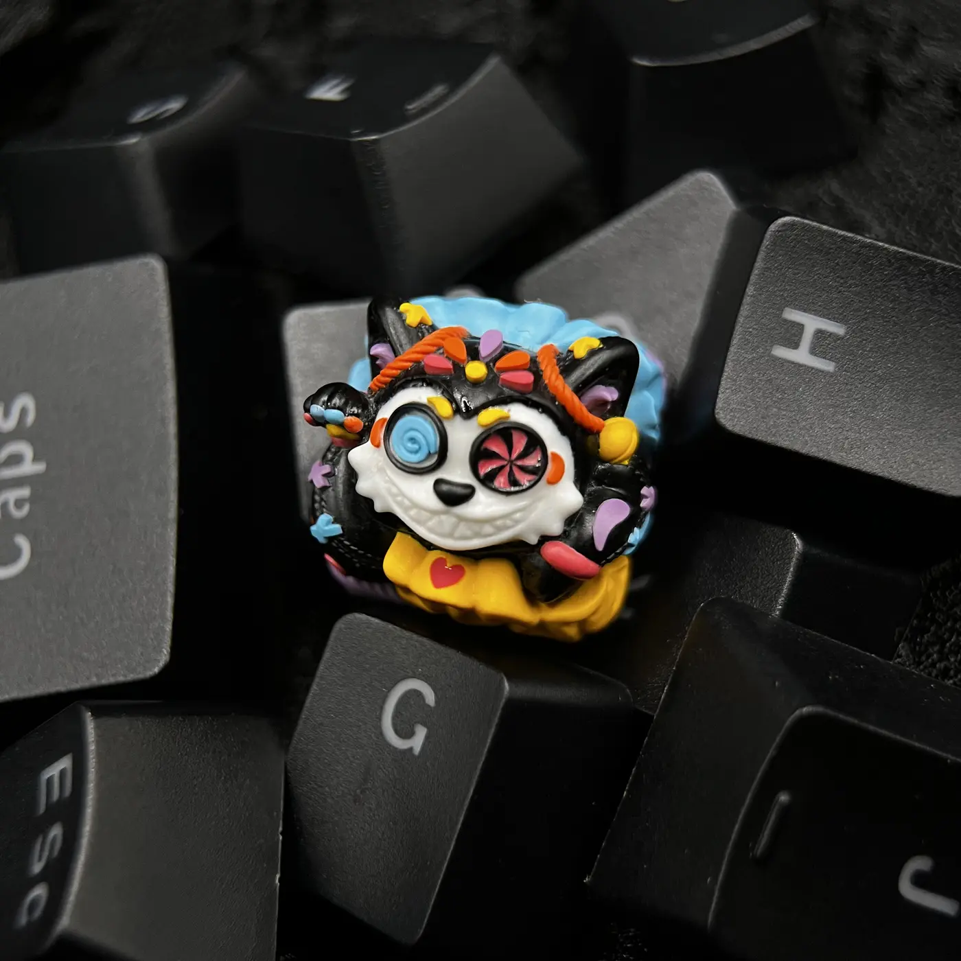Mictlán artisan keycap placed among black keyboard keys