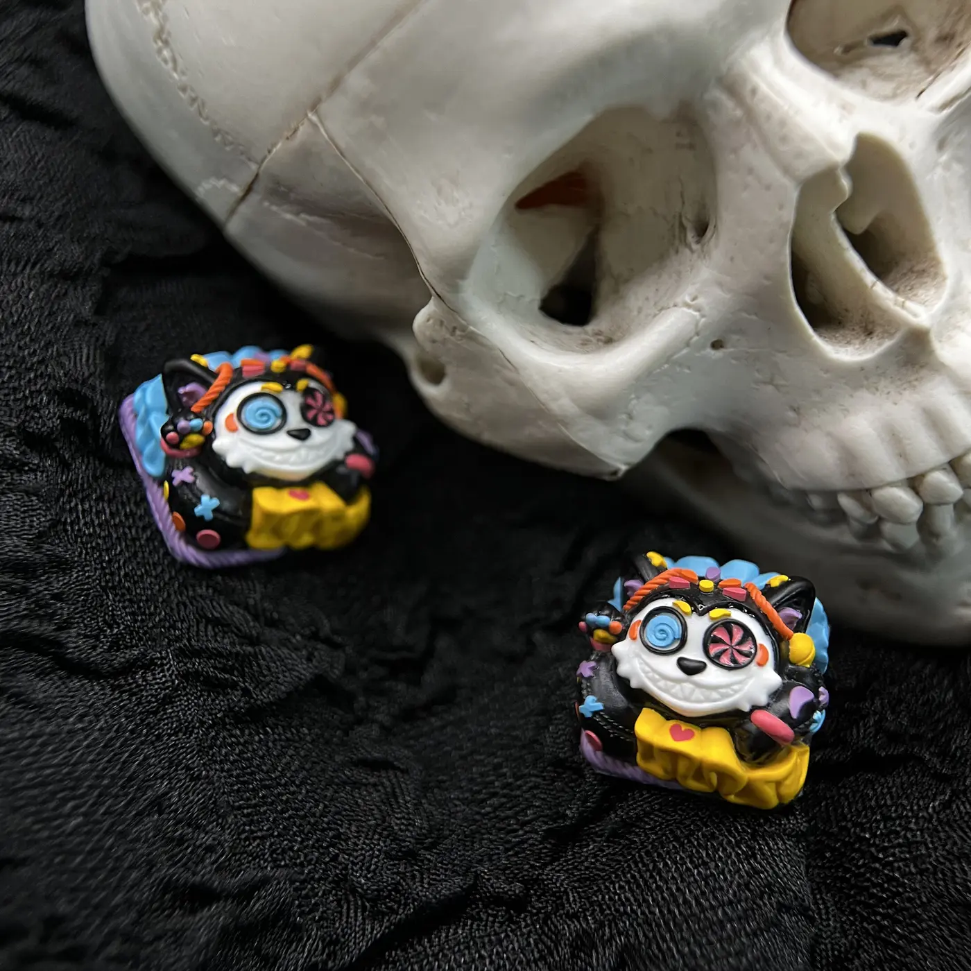 Two Mictlán artisan keycaps arranged beside a skull study